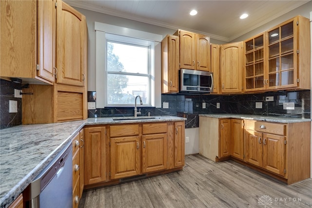 kitchen with dishwashing machine, stainless steel microwave, a sink, and crown molding