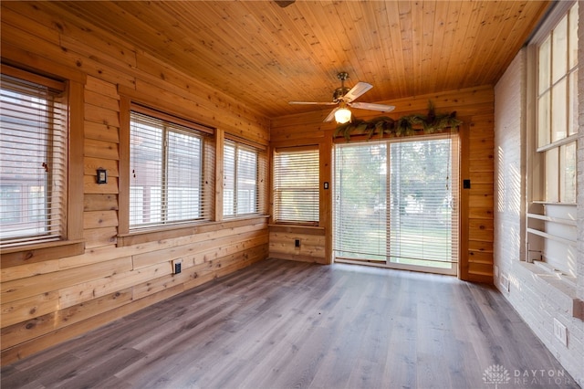 unfurnished sunroom featuring wood ceiling and a ceiling fan