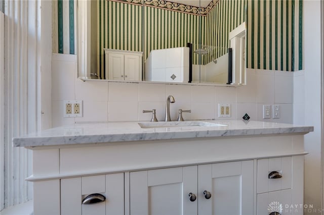 bathroom with vanity and wallpapered walls