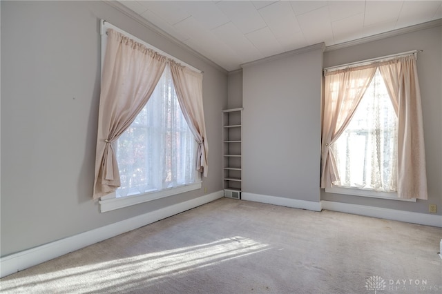 carpeted spare room with ornamental molding and baseboards