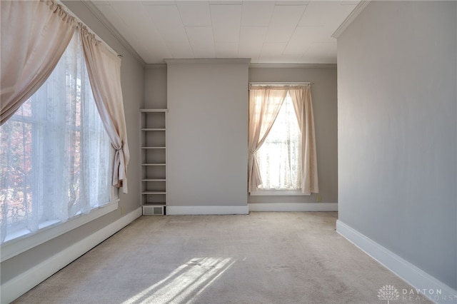 carpeted empty room featuring ornamental molding, visible vents, and baseboards