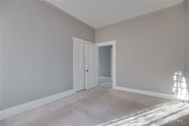 unfurnished bedroom featuring ornamental molding, carpet floors, and baseboards