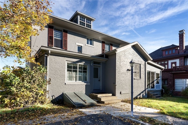 traditional style home featuring entry steps and brick siding