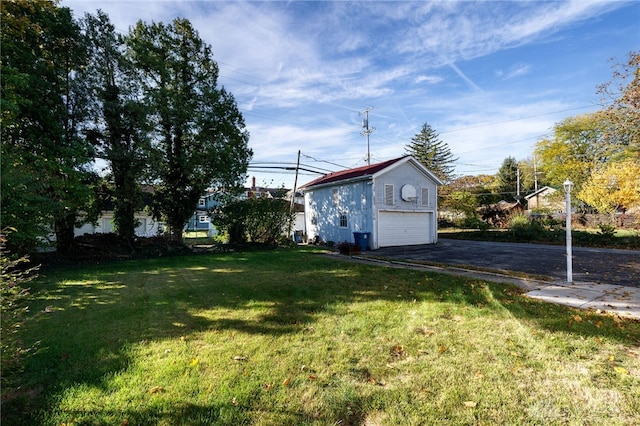 view of yard with an outbuilding and aphalt driveway