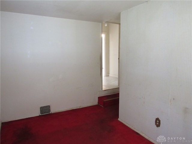 spare room featuring dark carpet