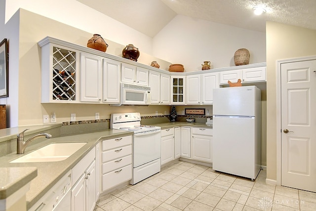 kitchen featuring white cabinets, a textured ceiling, vaulted ceiling, sink, and white appliances