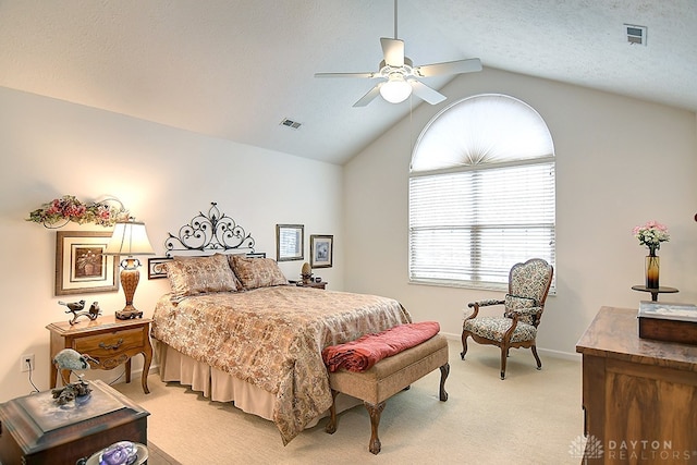 bedroom featuring lofted ceiling, light carpet, a textured ceiling, and ceiling fan