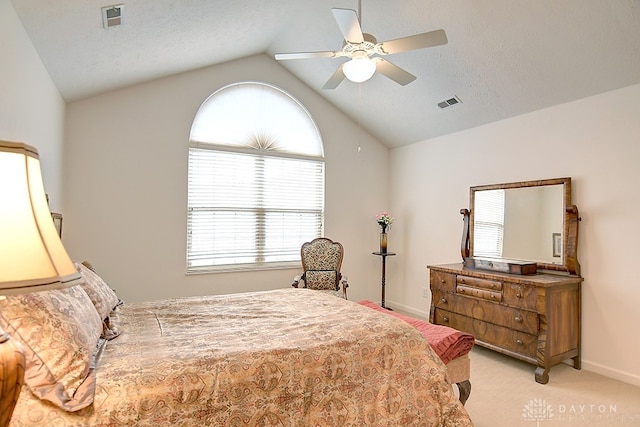 bedroom with lofted ceiling, a textured ceiling, light colored carpet, and ceiling fan