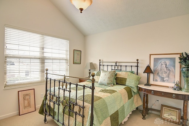 bedroom with a textured ceiling, lofted ceiling, and light colored carpet