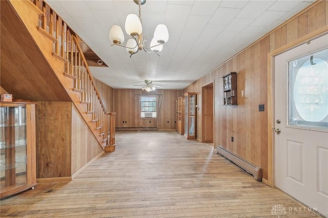 entryway featuring ceiling fan with notable chandelier, wood walls, light hardwood / wood-style floors, and a baseboard heating unit