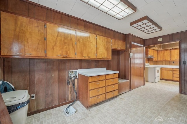 kitchen featuring wooden walls and white electric stove