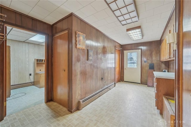 interior space featuring baseboard heating and wooden walls