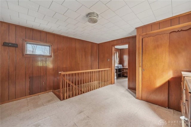 hallway featuring wooden walls