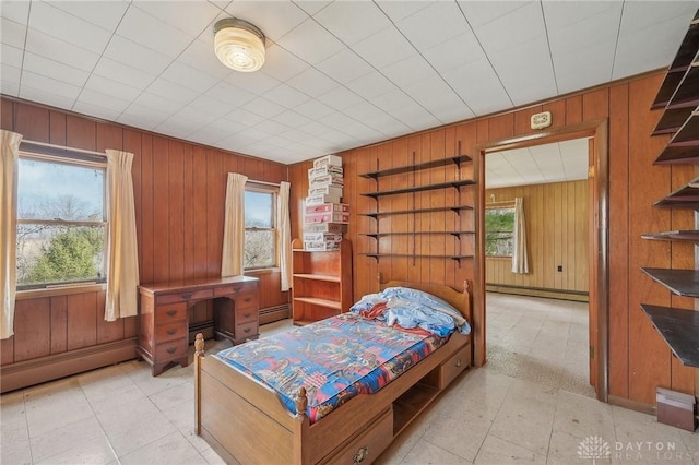 bedroom with a baseboard heating unit and wood walls