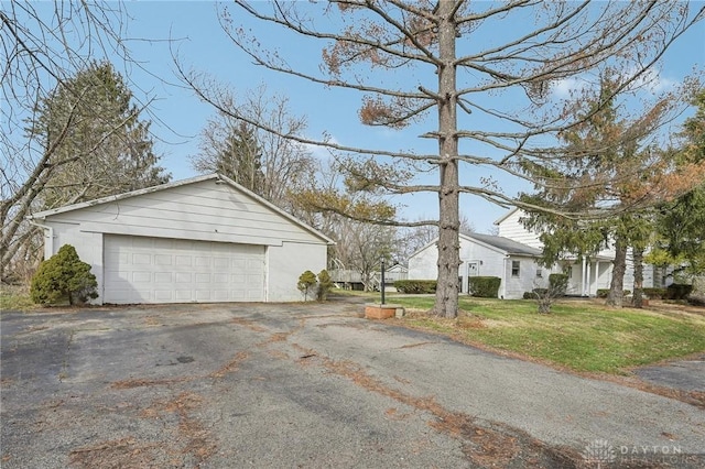 view of side of property featuring a garage and a lawn