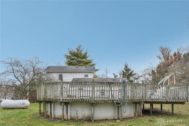 back of property featuring a deck and a lawn