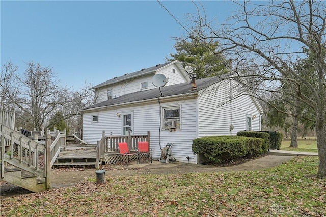 rear view of property featuring cooling unit and a wooden deck