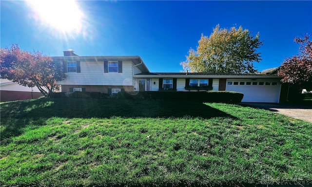 tri-level home featuring a front yard and a garage