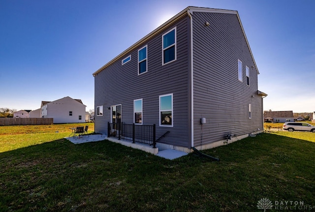 rear view of property with a patio area and a lawn