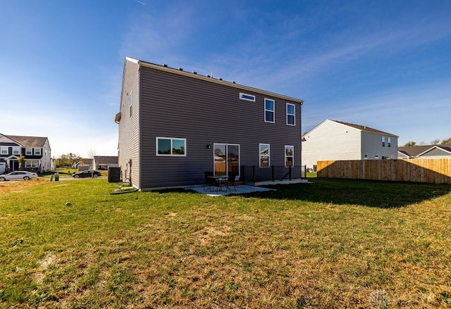 back of property with a patio, central AC, and a yard