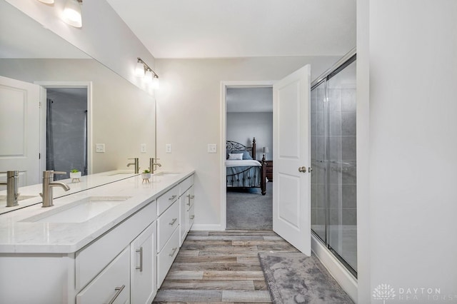 bathroom with vanity, a shower with shower door, and hardwood / wood-style flooring