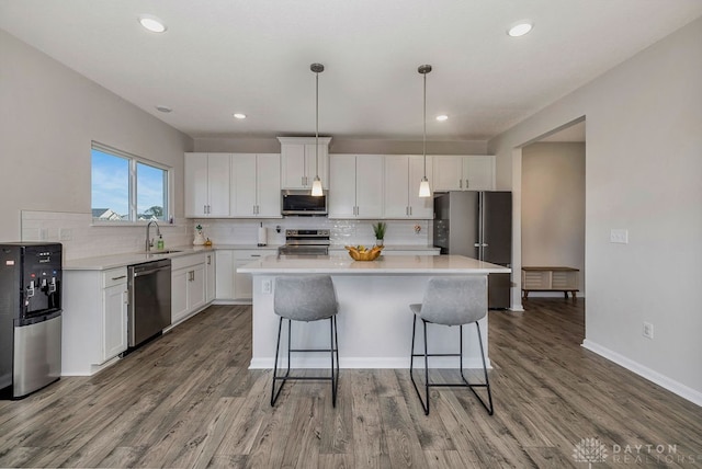 kitchen with a center island, appliances with stainless steel finishes, and white cabinetry