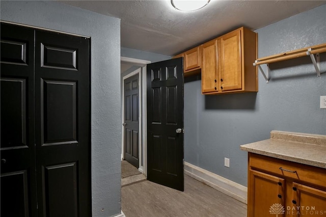 kitchen with light hardwood / wood-style floors and a textured ceiling