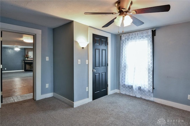 interior space featuring ceiling fan and carpet flooring