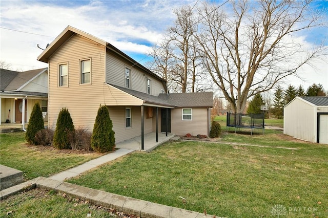 rear view of property with a storage unit, a yard, a patio, and a trampoline