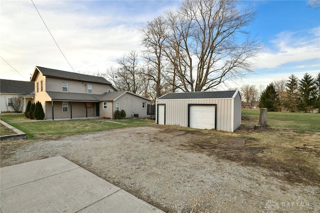 exterior space with an outbuilding, a garage, and a lawn