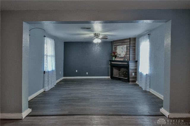 unfurnished living room with dark wood-type flooring and ceiling fan