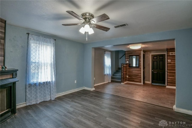 unfurnished living room with dark hardwood / wood-style floors and ceiling fan