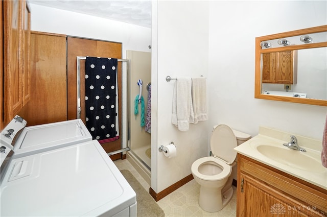 bathroom featuring vanity, toilet, washer and clothes dryer, and a shower with shower door