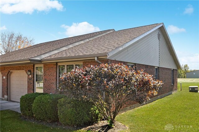 view of side of home with a garage and a lawn