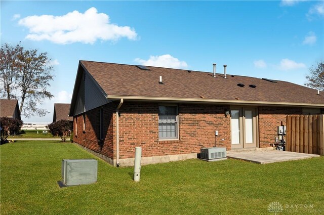 rear view of property with a patio, a yard, and central AC unit