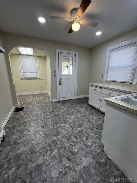 kitchen featuring white cabinets, ceiling fan, and sink