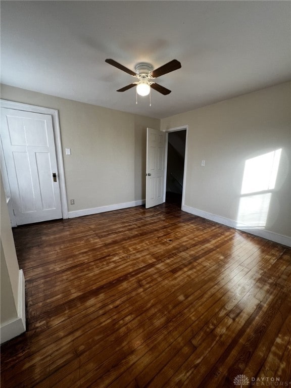 unfurnished room with ceiling fan and dark wood-type flooring