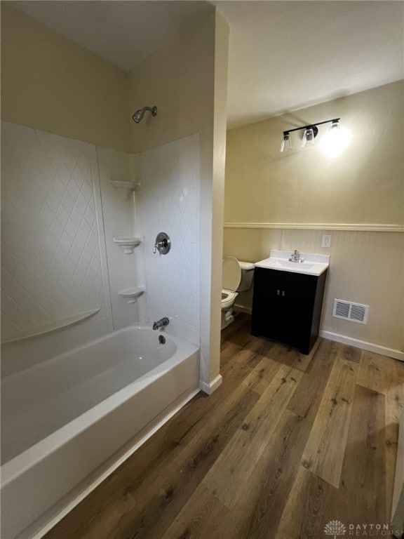 full bathroom featuring vanity, bathing tub / shower combination, hardwood / wood-style floors, and toilet