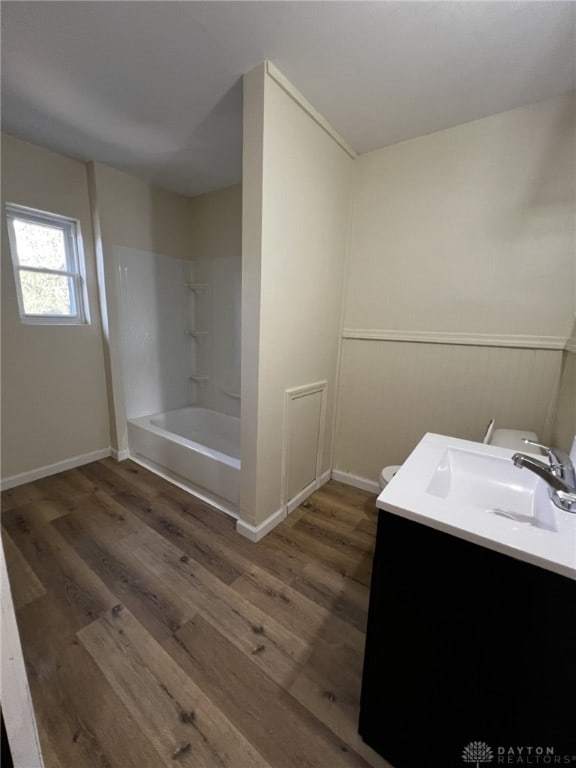 bathroom with wood-type flooring, shower / bathing tub combination, and vanity