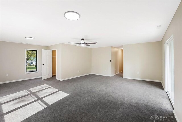 empty room featuring dark colored carpet and ceiling fan