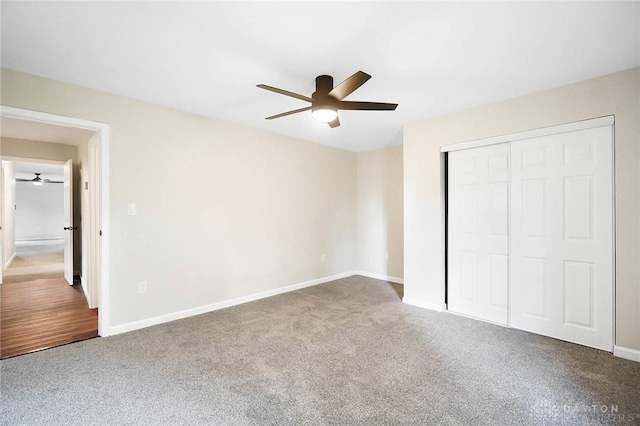 unfurnished bedroom featuring carpet floors, a closet, baseboards, and a ceiling fan