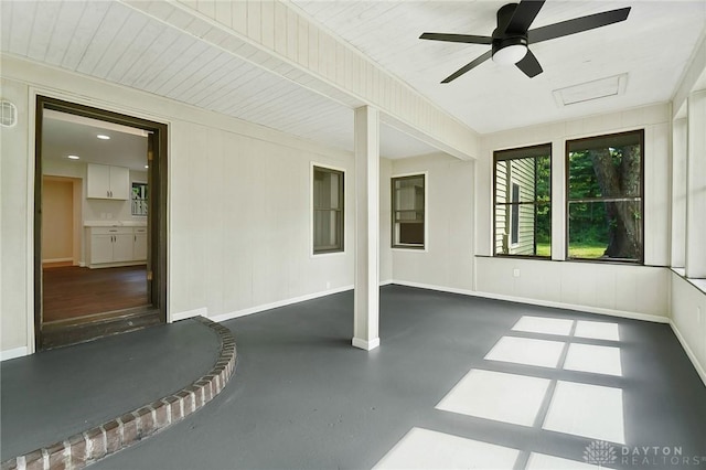 unfurnished sunroom featuring a ceiling fan