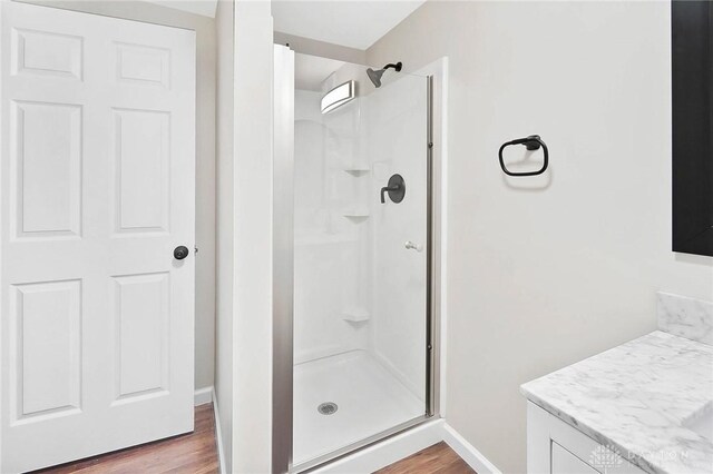 bathroom with a shower with door, wood-type flooring, and vanity