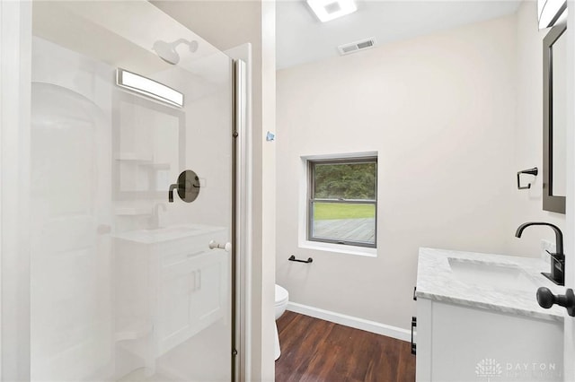 full bathroom with toilet, wood finished floors, vanity, visible vents, and baseboards