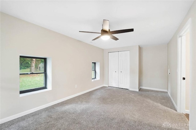 unfurnished bedroom featuring carpet floors, a closet, a ceiling fan, and baseboards