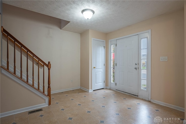 foyer with a textured ceiling