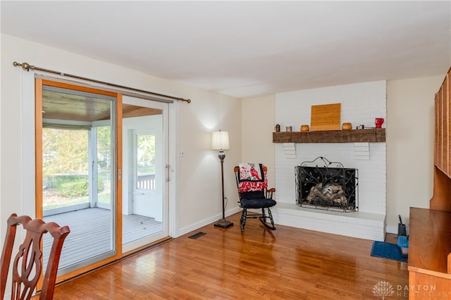 interior space with a brick fireplace and hardwood / wood-style floors