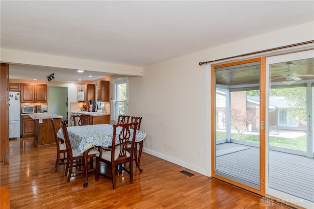 dining area featuring hardwood / wood-style floors, ceiling fan, sink, and a wealth of natural light