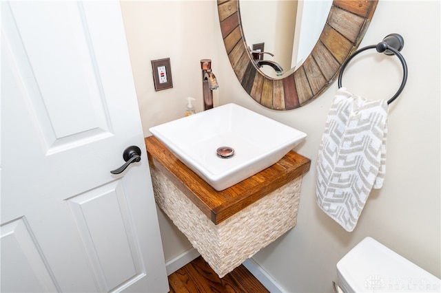 bathroom featuring toilet and wood-type flooring