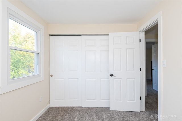 unfurnished bedroom with carpet flooring and a closet